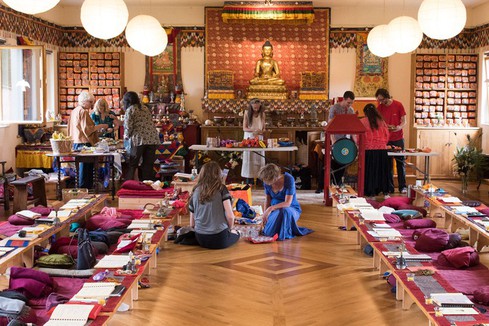 People inside the gompa - meditation hall - preparing for a Buddhist Dharma teaching.