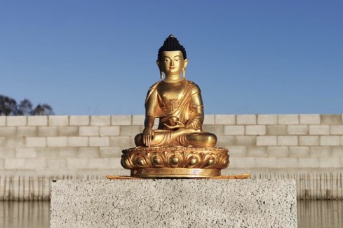 Golden Buddha statue at temple foundations in Yorkshire, England, UK.