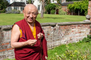 Chokyi Nyima Rinpoche next to an old wall at Lindholme Hall