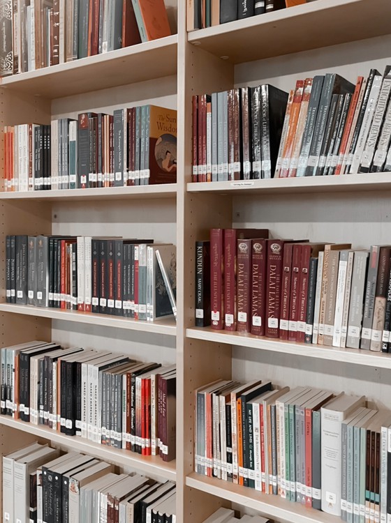 Dharma books on shelves in a Buddhist religious library in Yorkshire, UK.