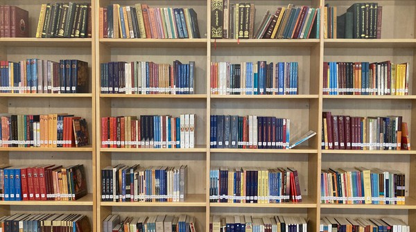 Buddhist library with shelves full of dharma texts and books.
