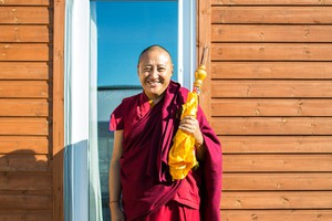 Lama Oser resident monk and teacher in front of a door.