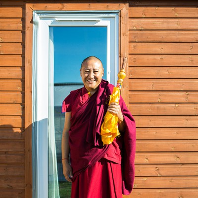 Lama Oser resident monk and teacher in front of a door.