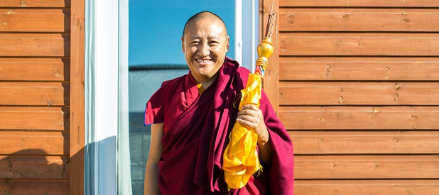Lama Oser resident monk and teacher in front of a door.