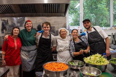 Smiling group of kitchen volunteers at Buddhist Centre in Yorkshire UK.