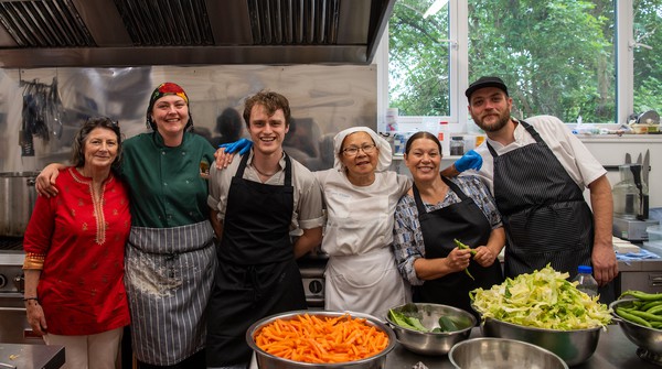 Buddhist-volunteers-community-service Smiling group of kitchen volunteers at Buddhist Centre in Yorkshire UK.