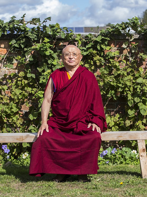 Chokyi Nyima Rinpoche Spiritual Director seated on a bench outside at Gomde UK.