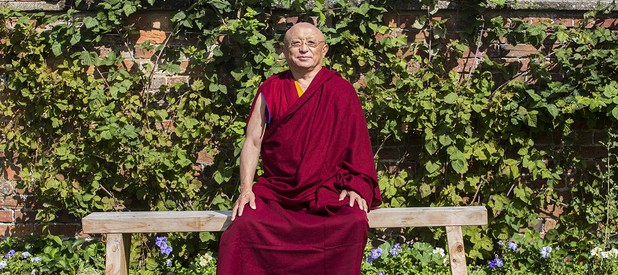 Chokyi Nyima Rinpoche Spiritual Director seated on a bench outside at Gomde UK.