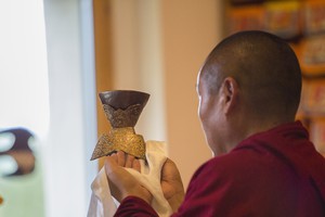 Dharma Teacher Lama Oser Meditation Hall Buddhist monk and dharma teacher with religious shire objects in a meditation hall.