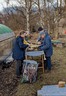 Environmental Conferences Group of people in warm coats working around a table outside, propagating mosses.