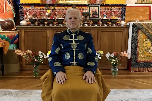 Erric Solomon in traditional dress in Buddhist meditation hall.