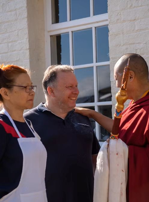 Buddhist monk with two volunteers and meditation practitioners.