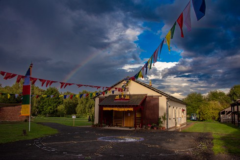 Buddhism meditation hall Buddhism meditation hall for worship, in the dark, with prayer flags and a rainbow.