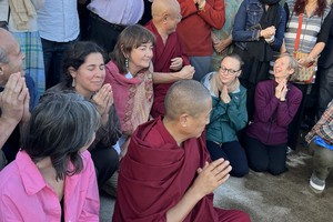 Joyous faces of people saying prayers at Buddhist Temple site.
