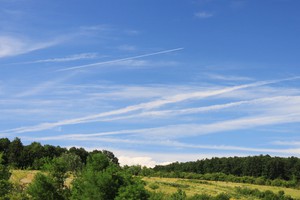Vast blue skies above Buddhist Meditation Centre Gomde UK with plane contrails.